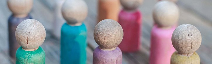 Eine Reihe bunter Spielfiguren aus Holz